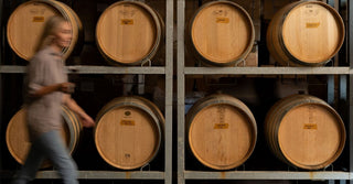 Penelope Radburnd, winemaker, walking through the Radburnd Cellars winery alongside French oak barrels